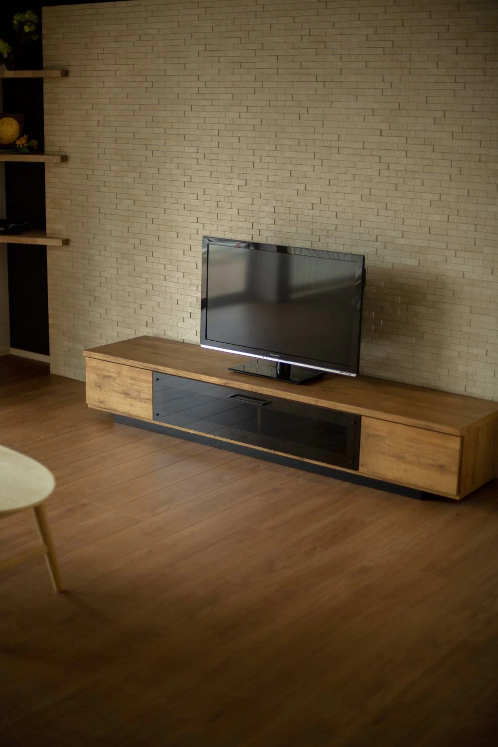テレビの後ろ壁にはレンガ調の壁を使用し異素材をミックス